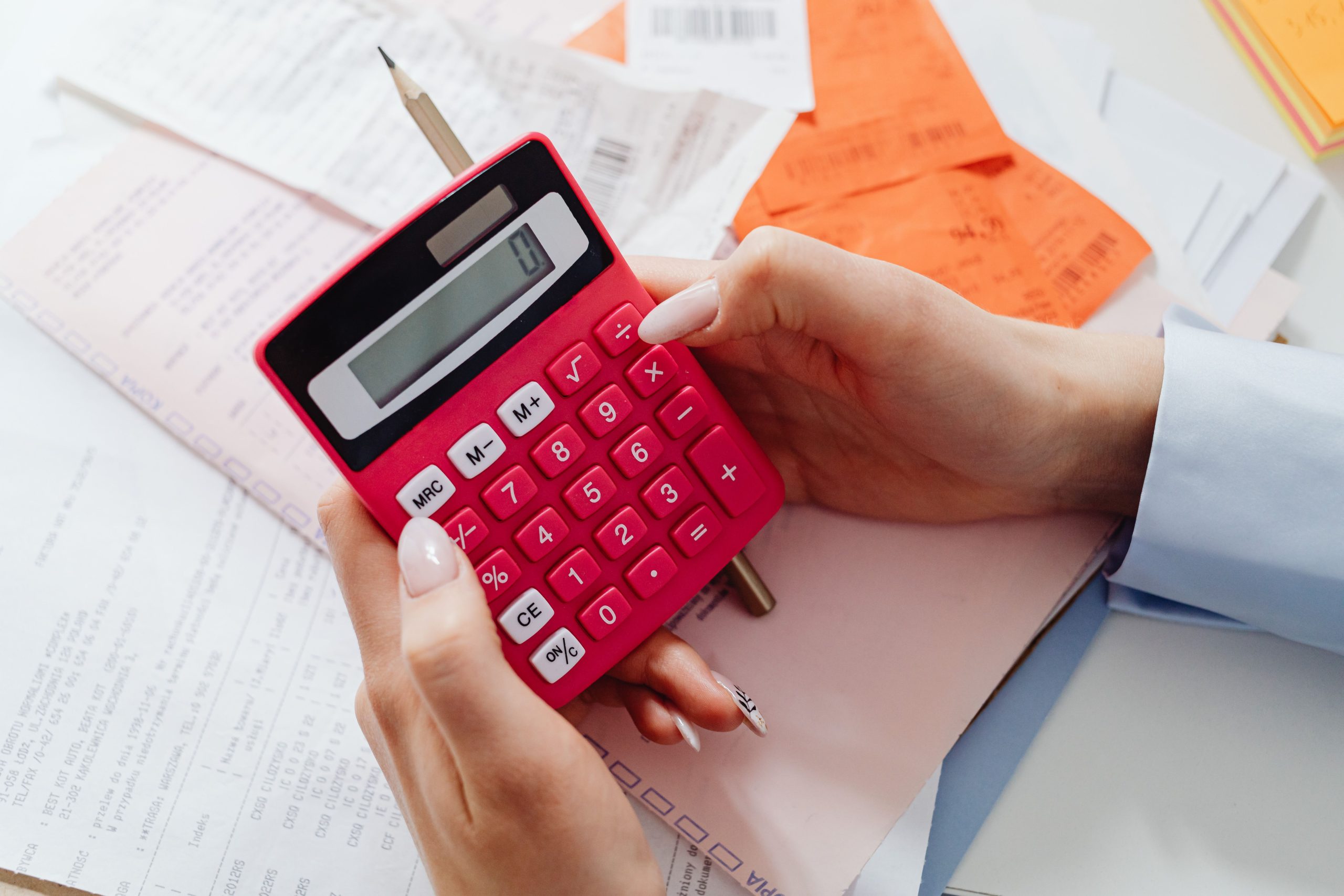 Mains tenant calculatrice rouge et documents