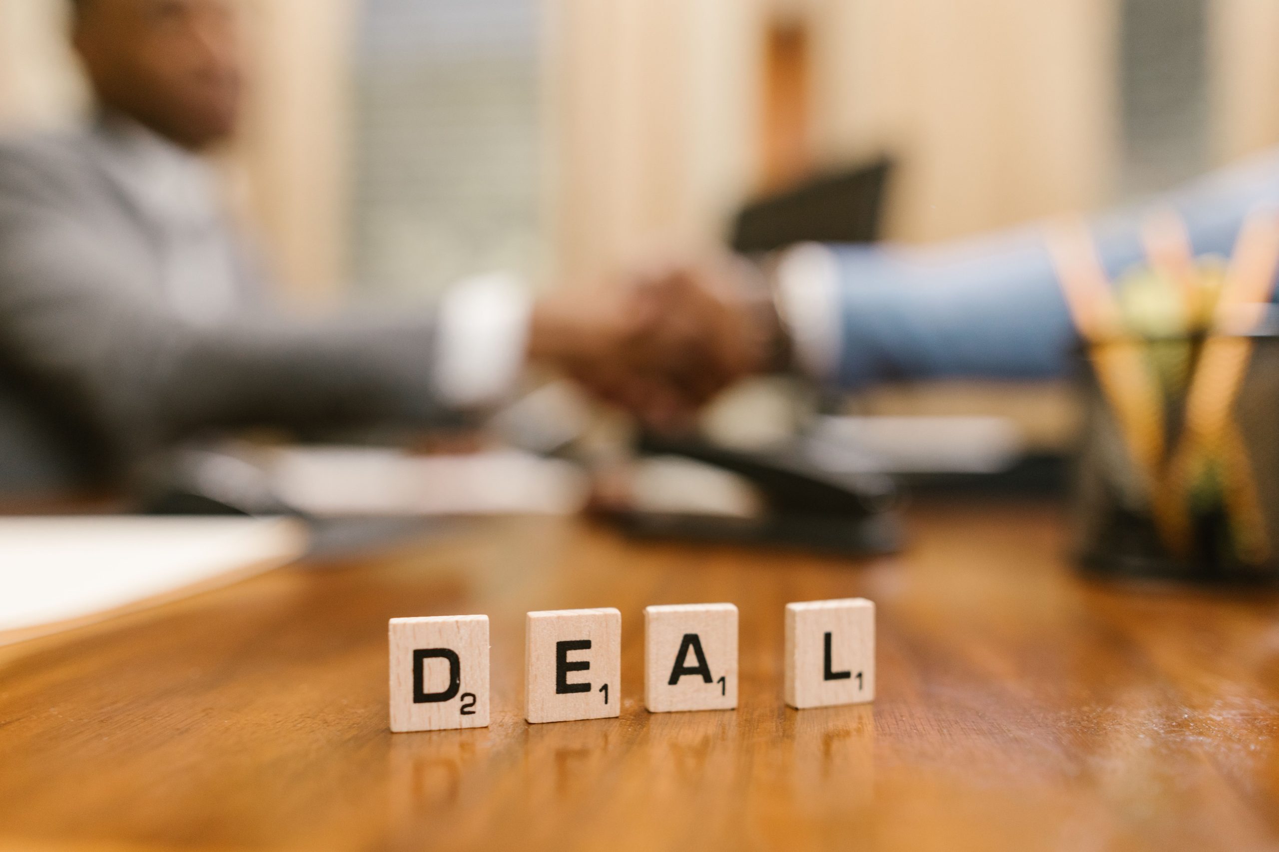 Tuiles de scrabble orthographiant deal et poignée de main