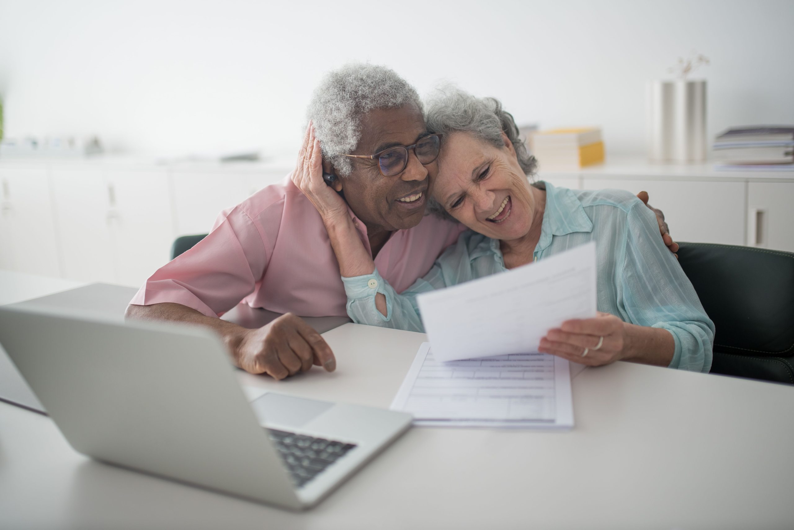 Couple senior souriant examinant documents ensemble