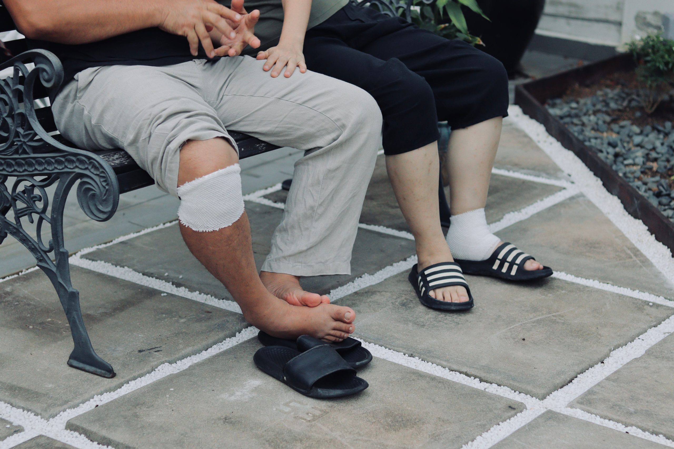 Couple assis dehors avec jambes bandées après blessure