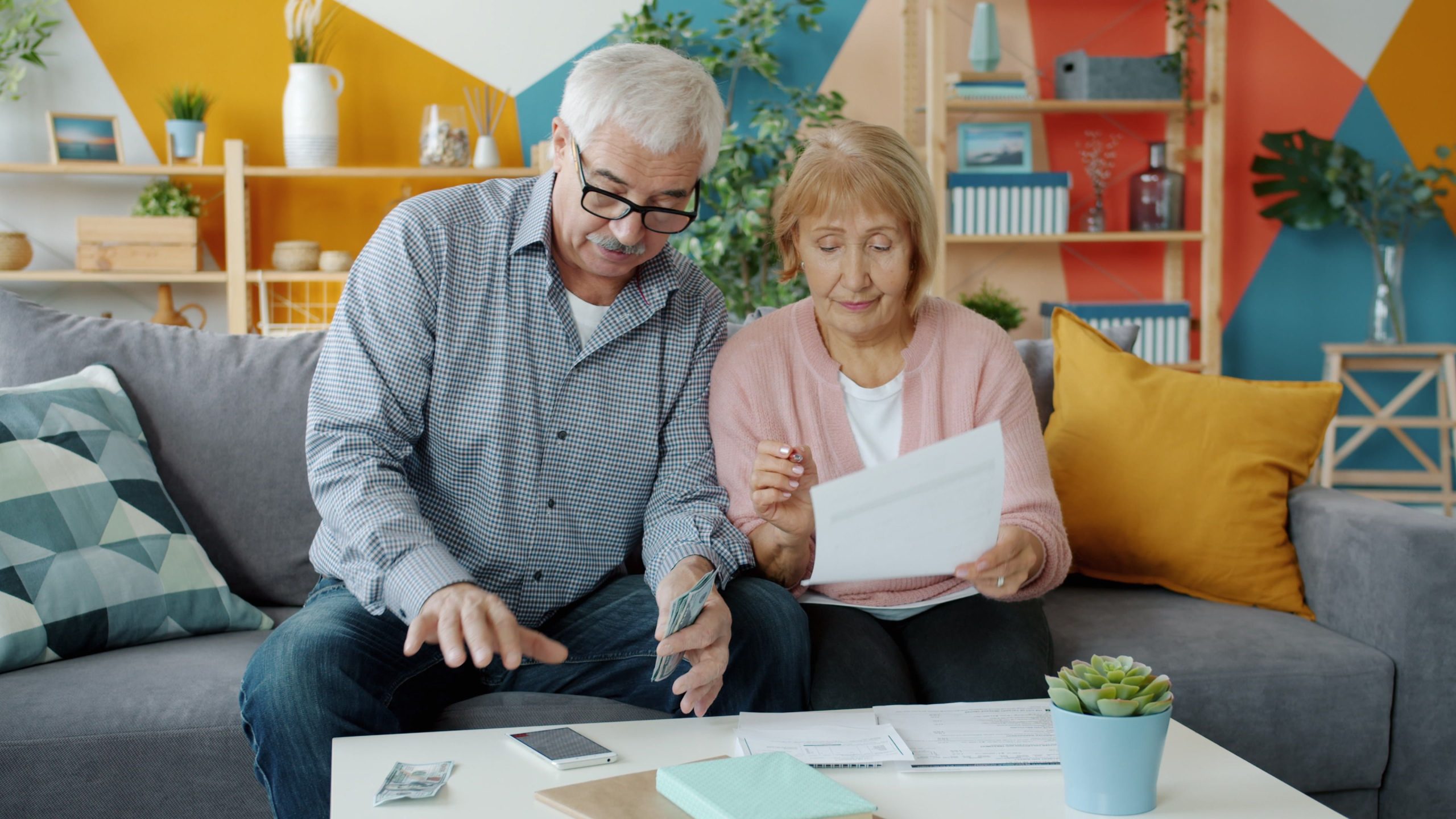 Couple de seniors examinant budget et documents à domicile