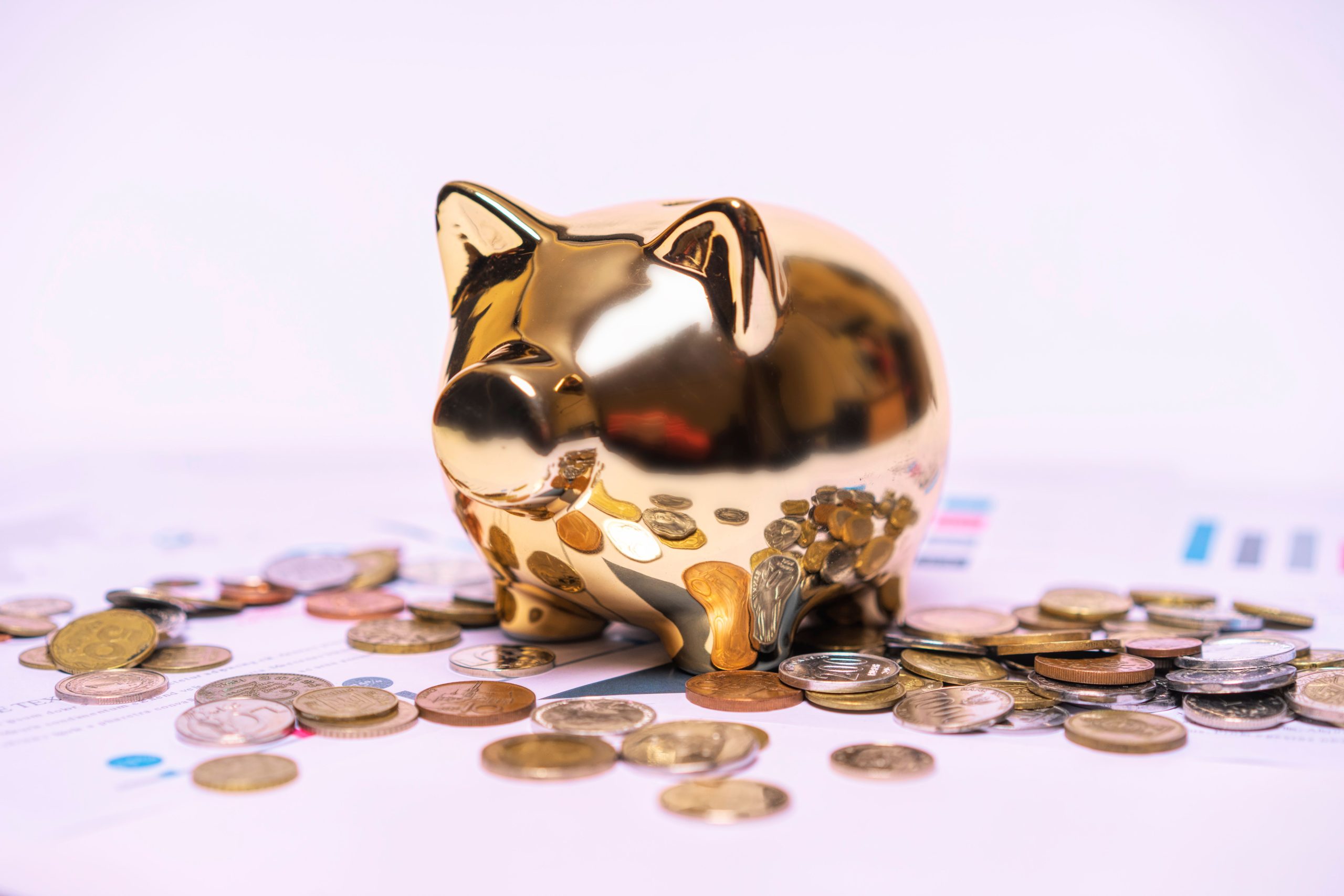 Tirelire doree sur documents financiers avec pieces dispersees