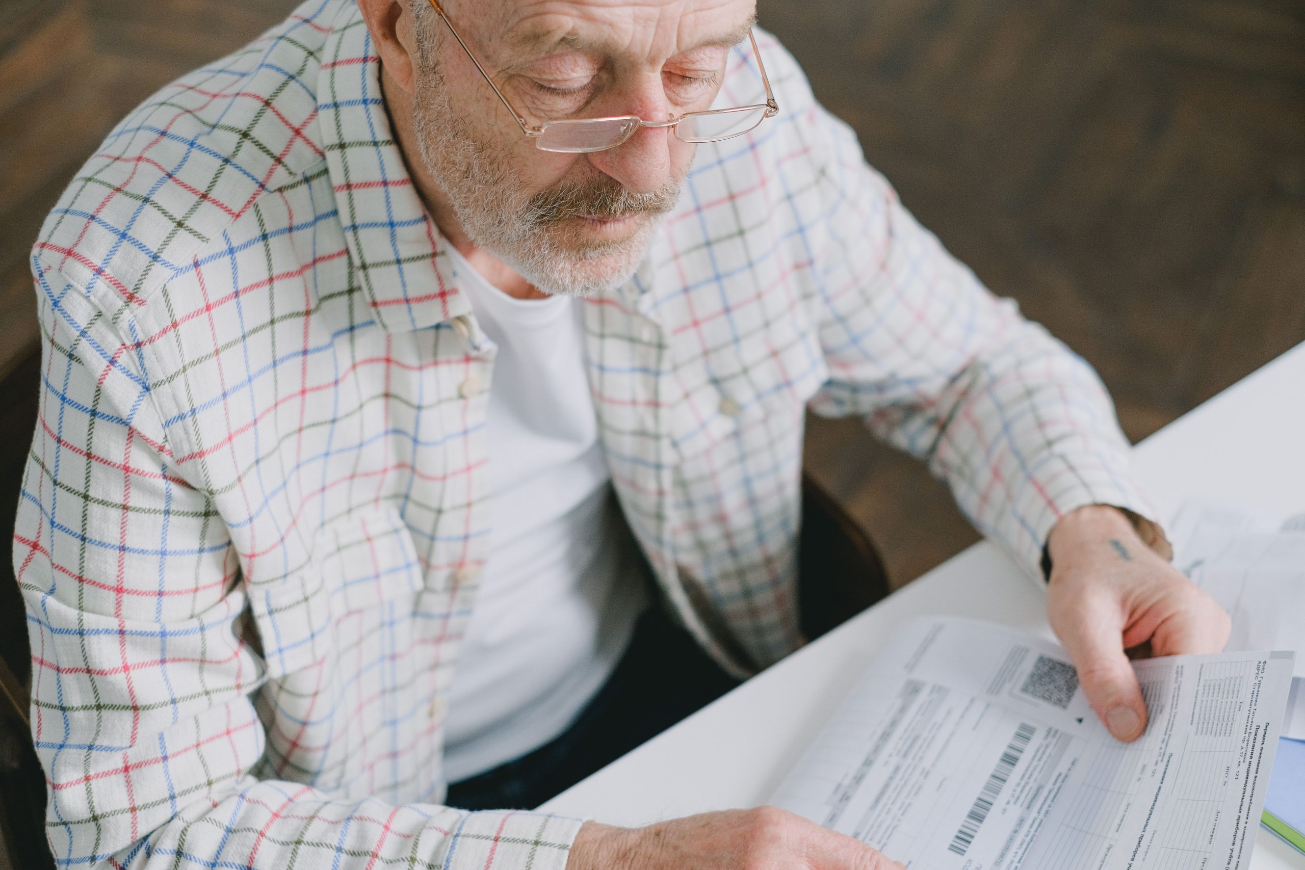 Senior concentré analysant documents personnels à la maison