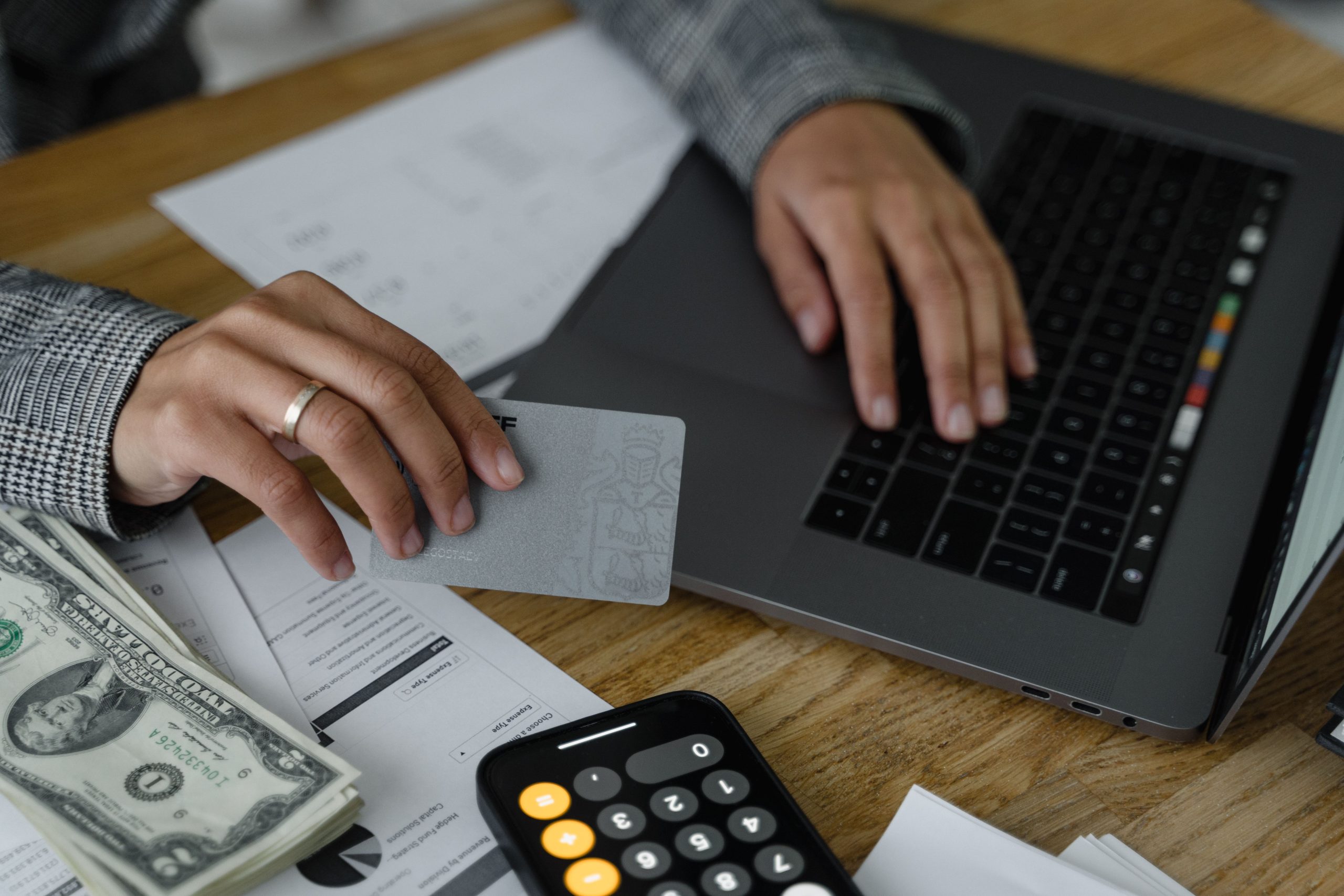 Personne utilisant carte crédit et ordinateur portable avec calculatrice