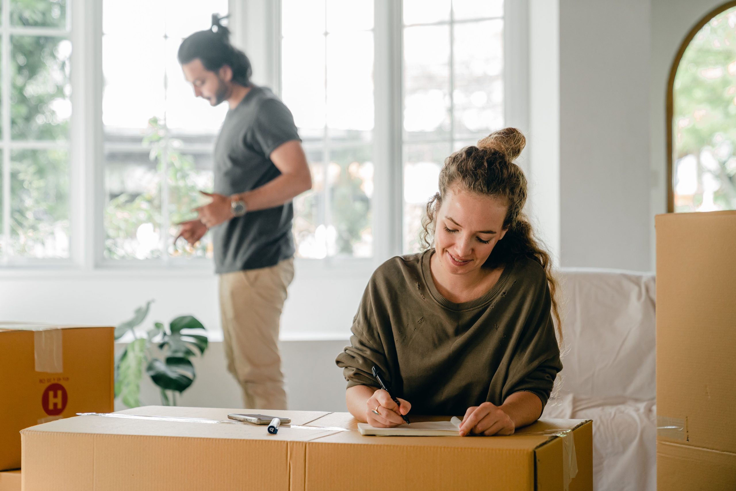 Femme écrivant cartons déménagement maison nouvelle