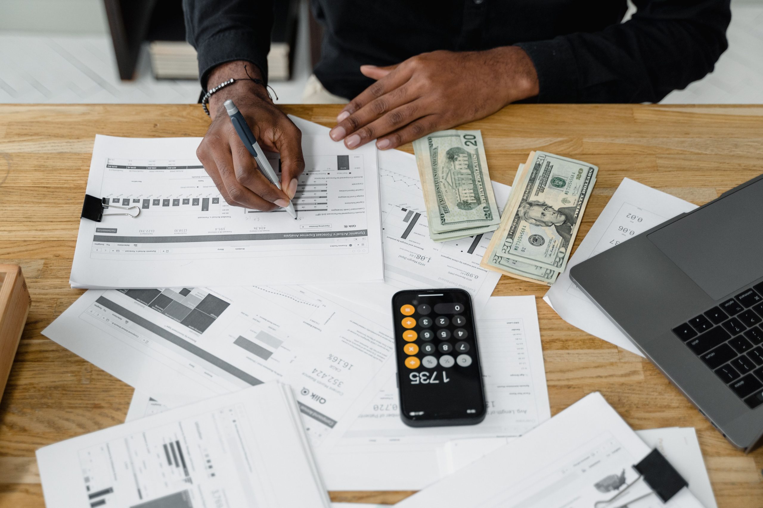 Homme analysant rapports financiers avec calculatrice et argent