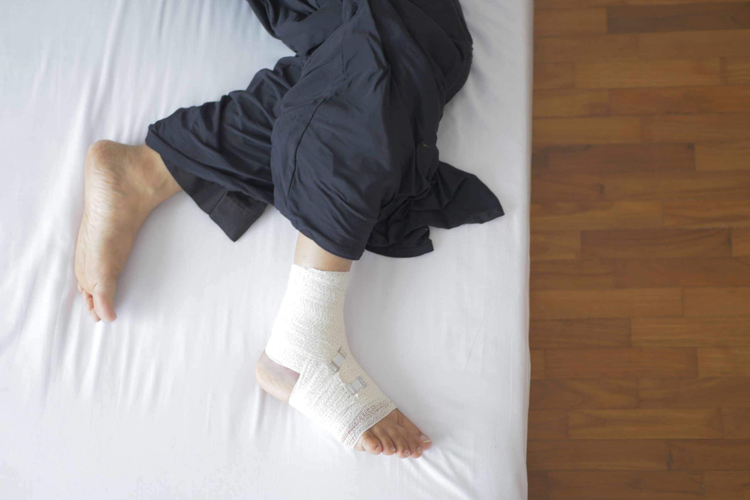 Pied bandé reposant sur un lit après blessure