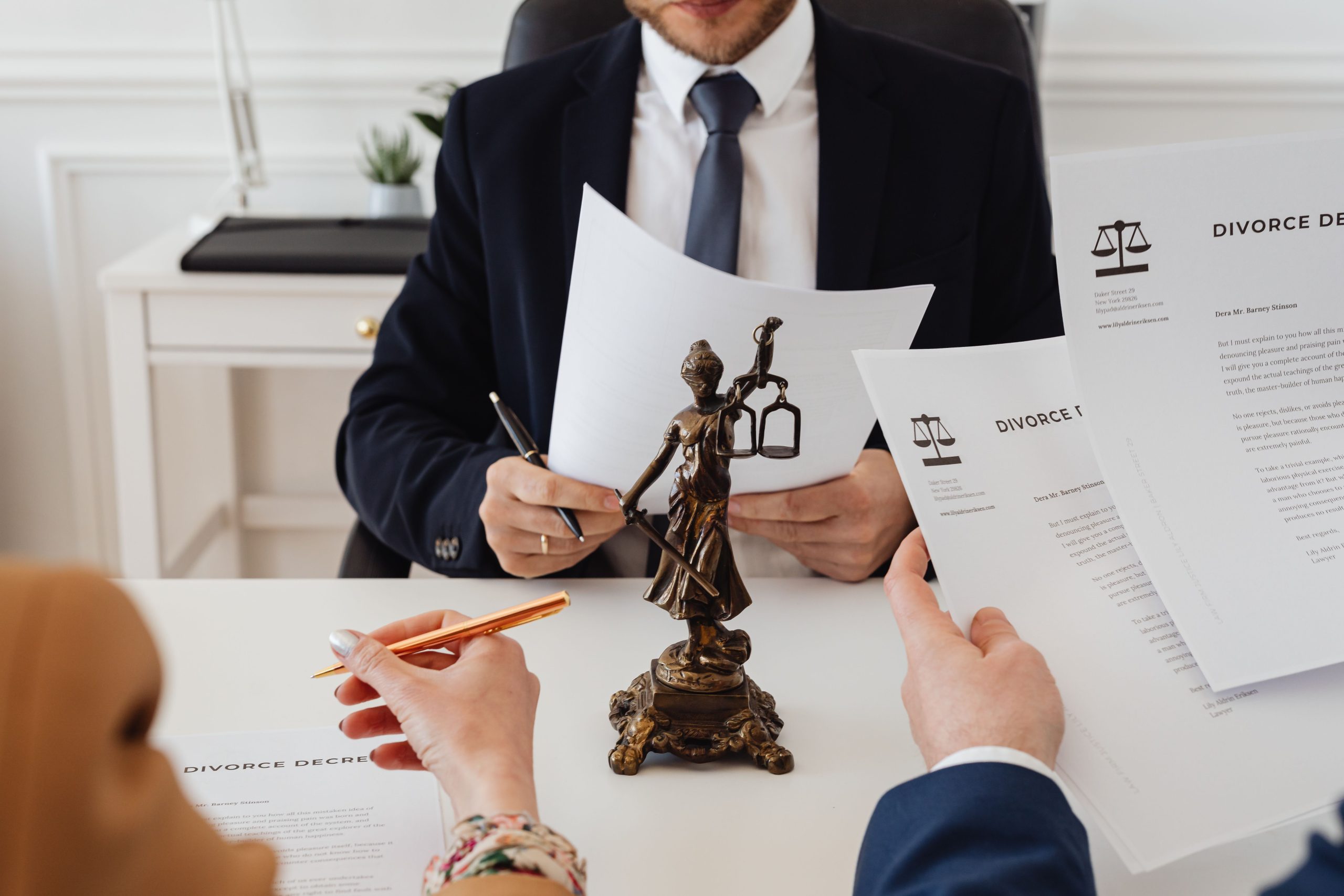 Juristes examinant des documents de divorce avec statue de la justice