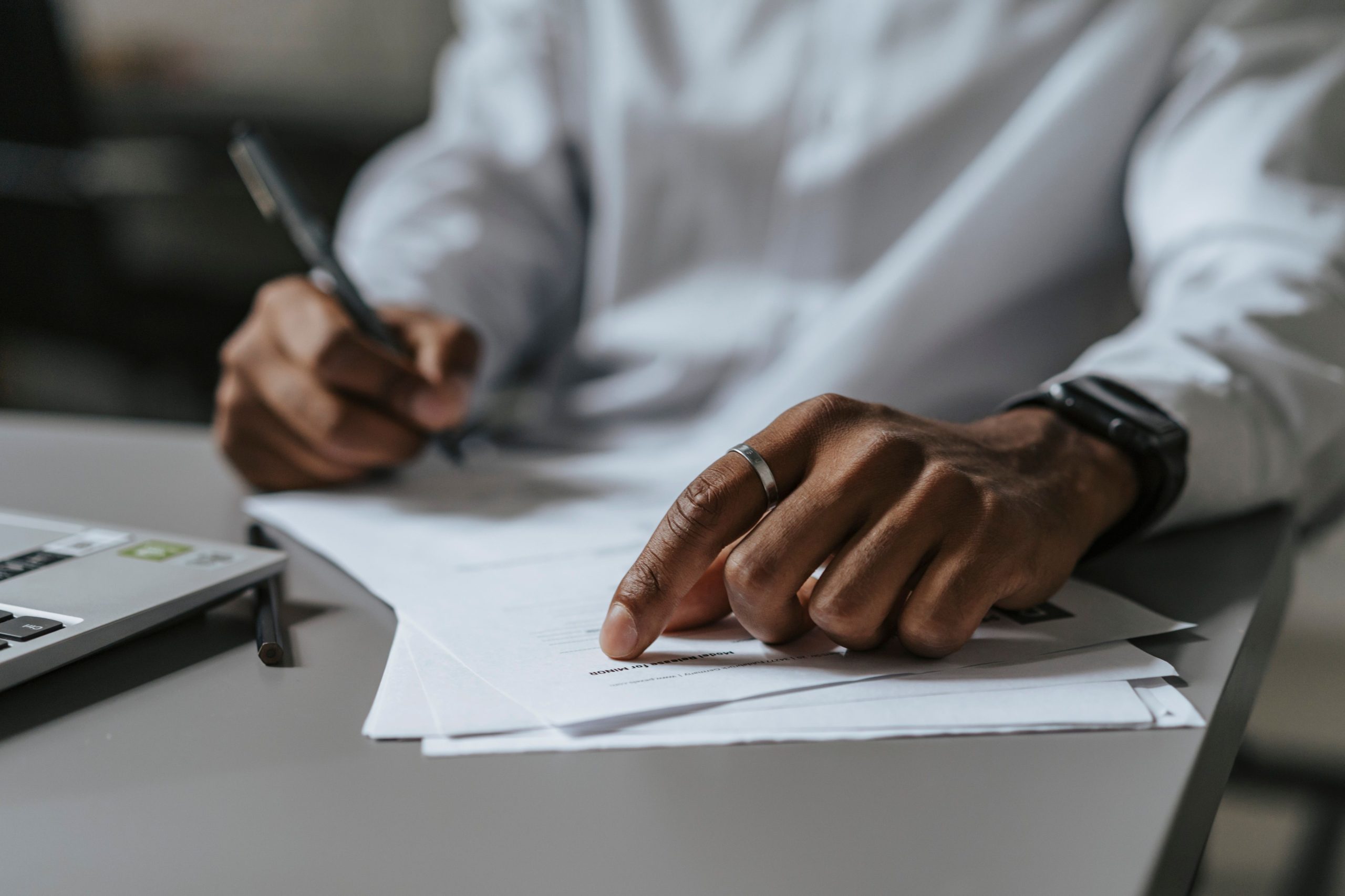 Professionnel écrivant sur des documents au bureau