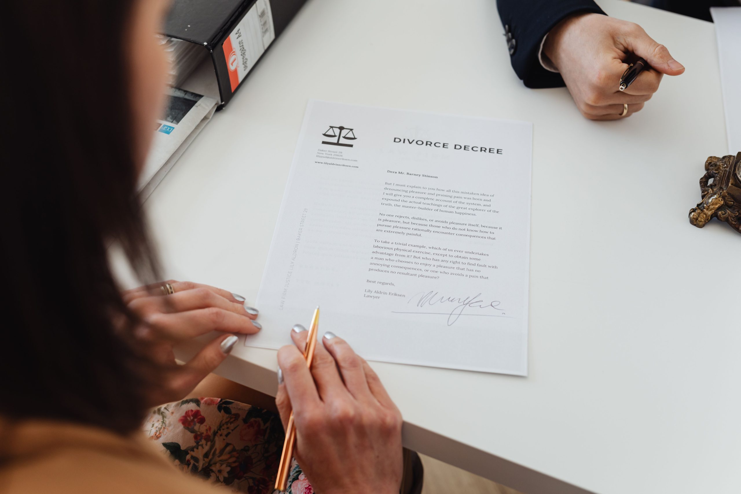 Deux personnes signant un acte de divorce sur une table