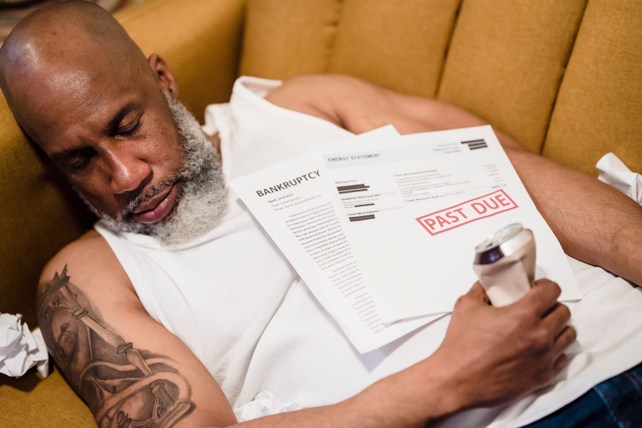 Homme endormi sur documents financiers stressants