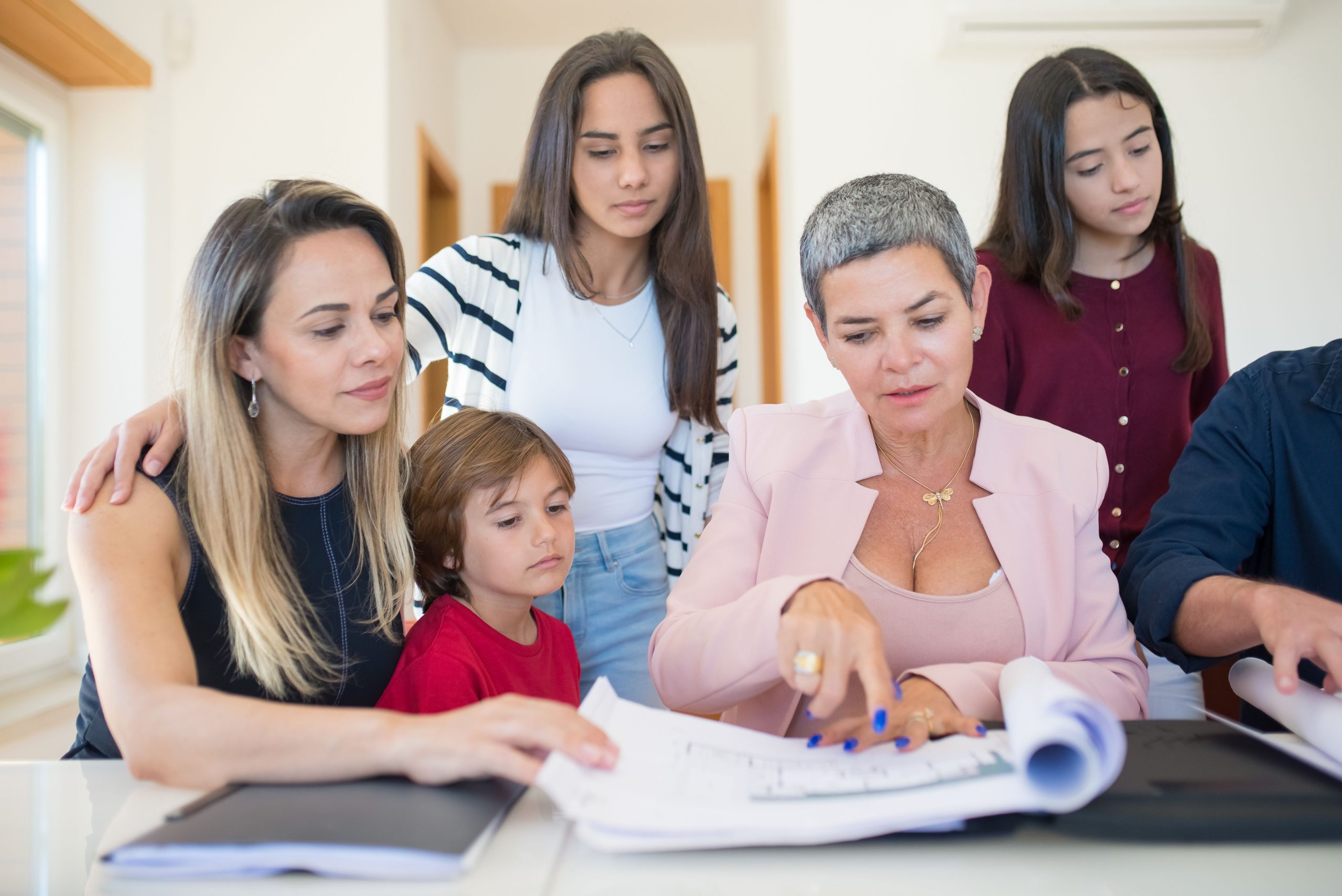 Famille examinant documents immobiliers avec agent